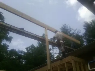 Carpenter setting a ridge beam over a new addition frame — Ice Dam Removal by Roofing Brothers in New Bremen