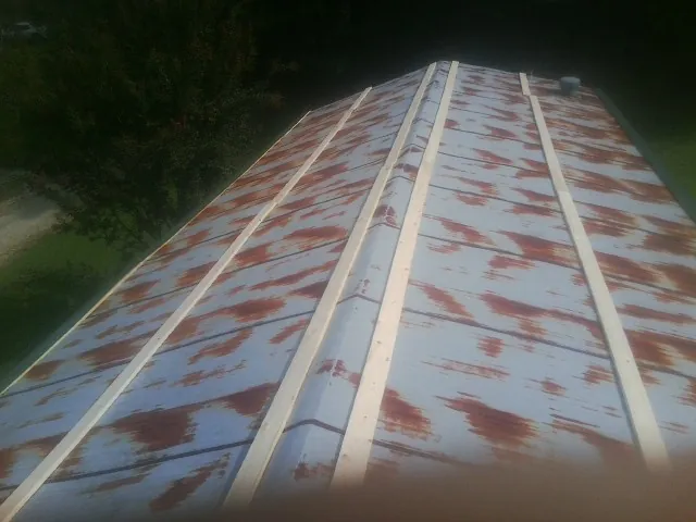 Rusted metal roof panels with new wood purlins before replacement — Storm Damage Roof Repair in New Bremen by Roofing Brothers